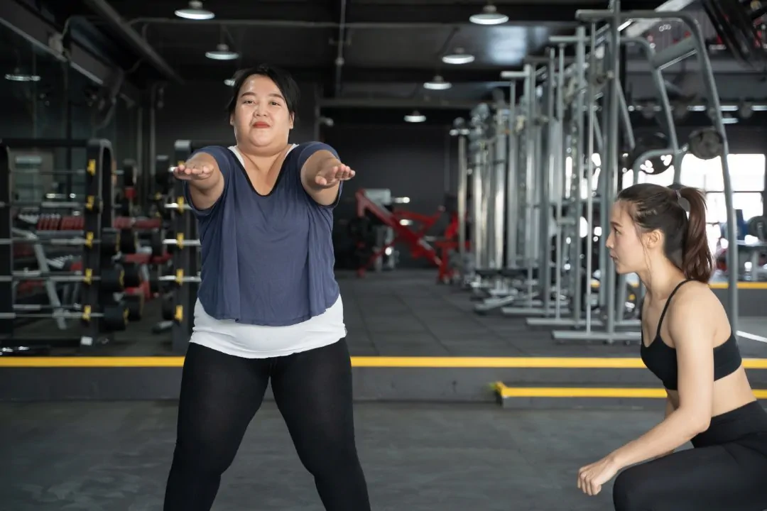 obese asian woman and her personal trainer doing urology expert